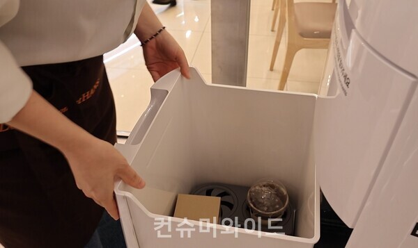한스 코엑스점 직원이 실내 배달 로봇에 주문한 음료(커피)를 싣고 있다./사진: 전휴성 기자