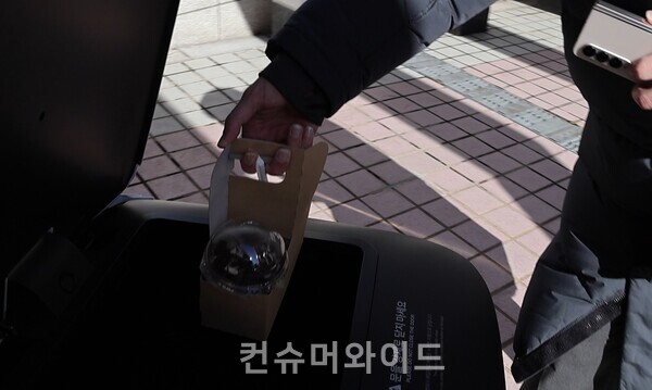 직원이 계단을 올라와 실외 배달 로봇에 주문한 음료(커피)를 싣고 있다./사진: 전휴성 기자
