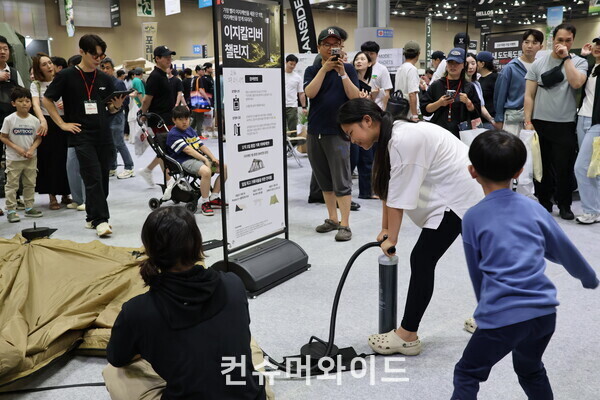 25일 ‘2024 고카프 킨텍스’ 내에서 진행된 이벤트에서 한 여핵생이 남성 어른도 힘들어하는 에어텐트에 공기 빨리 주입하기 이벤트에 도전하고 있다.  ⓒ컨슈머와이드 강진일 기자