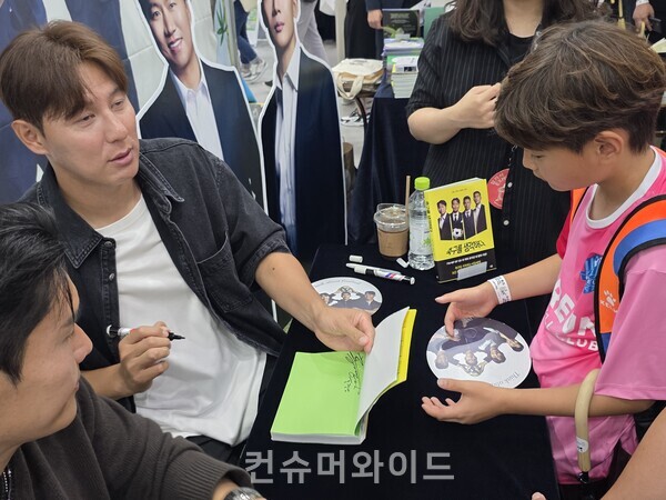 홍정남 선수가 어린이 선수에게 격려하며 사인해 주고 있는 모습 ⓒ컨슈머와이드 강진일 기자