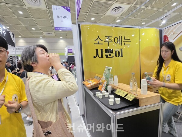 우리두의 사뿐히 부스에서 여성 관람객이 시음하고 있다.  ⓒ컨슈머와이드 강진일 기자