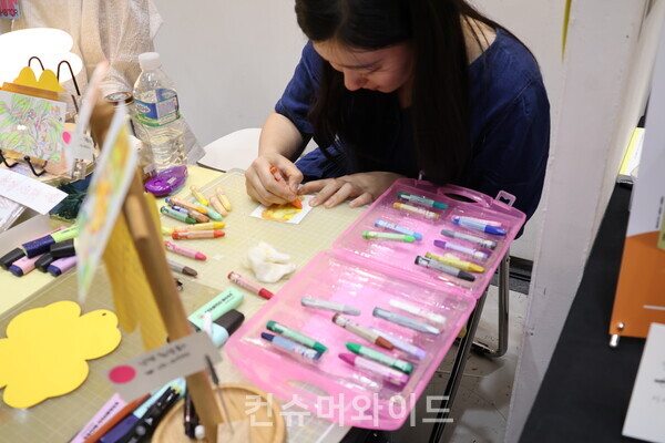 초상화를 크레파스로 그려주는 작가 모습ⓒ컨슈머와이드 전휴성 기자